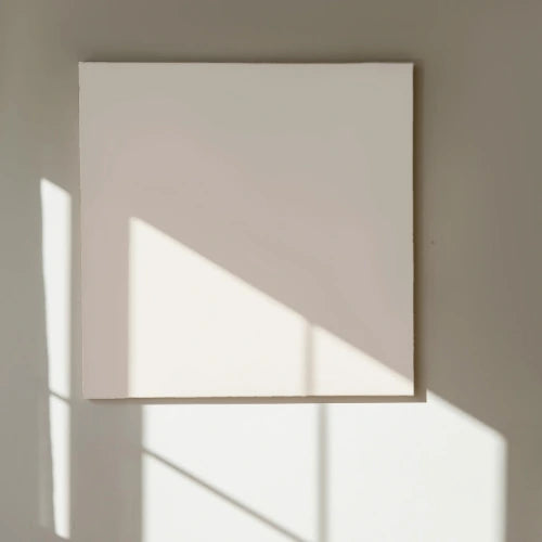 Square light fixture casting a shadow on a wall