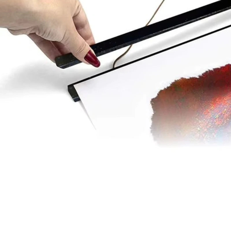 Hand using a tool to remove a red stain from a white surface