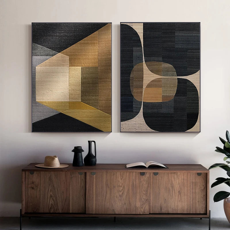 Two abstract art pieces on a wall above a wooden console table.