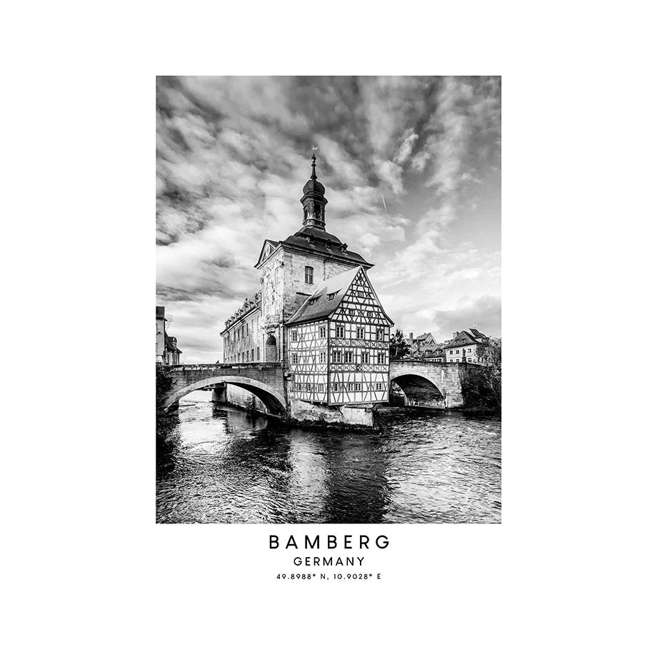 Black and white photo of a historic building in Bamberg, Germany with a river and bridge.