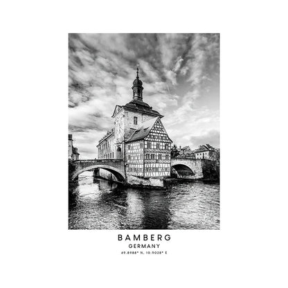 Black and white photo of a historic building in Bamberg, Germany with a river and bridge.
