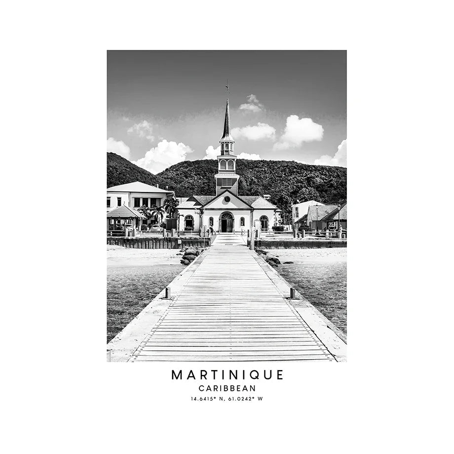 Black and white image of a church with a steeple and a dock leading to it, set against a mountainous background.