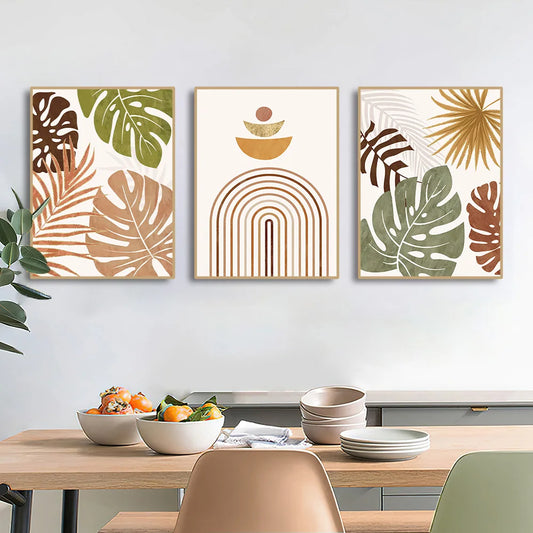 Three framed artworks with leaf and abstract designs above a dining table with food. Canvas & Curio
