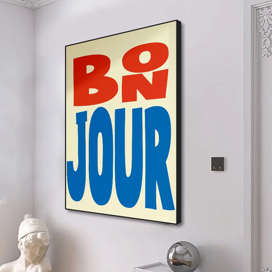 Decorative wall art with 'BO N JOUR' text in red and blue on a beige background, mounted on a white wall. Canvas & Curio