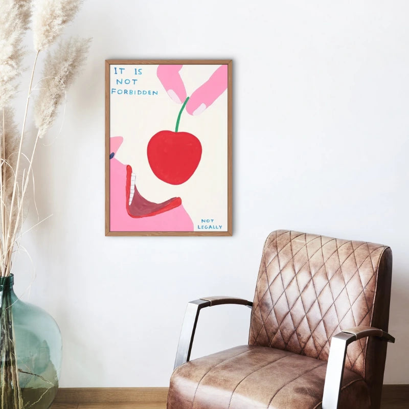 Framed artwork with a red apple and text on a wall above a brown armchair.