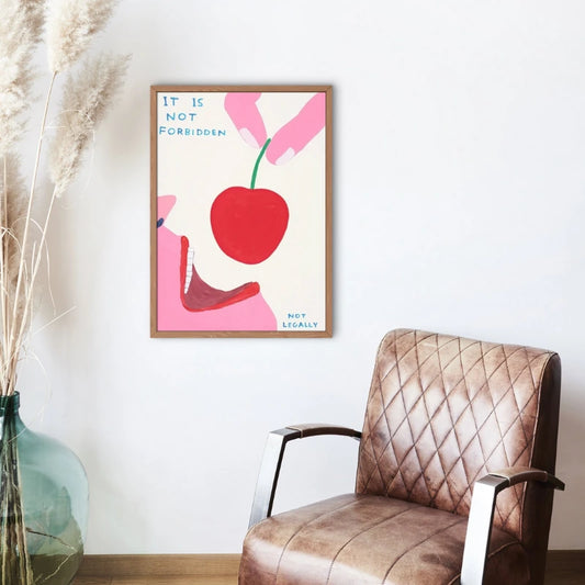 Framed artwork with a red apple and text on a wall above a brown armchair. Canvas & Curio