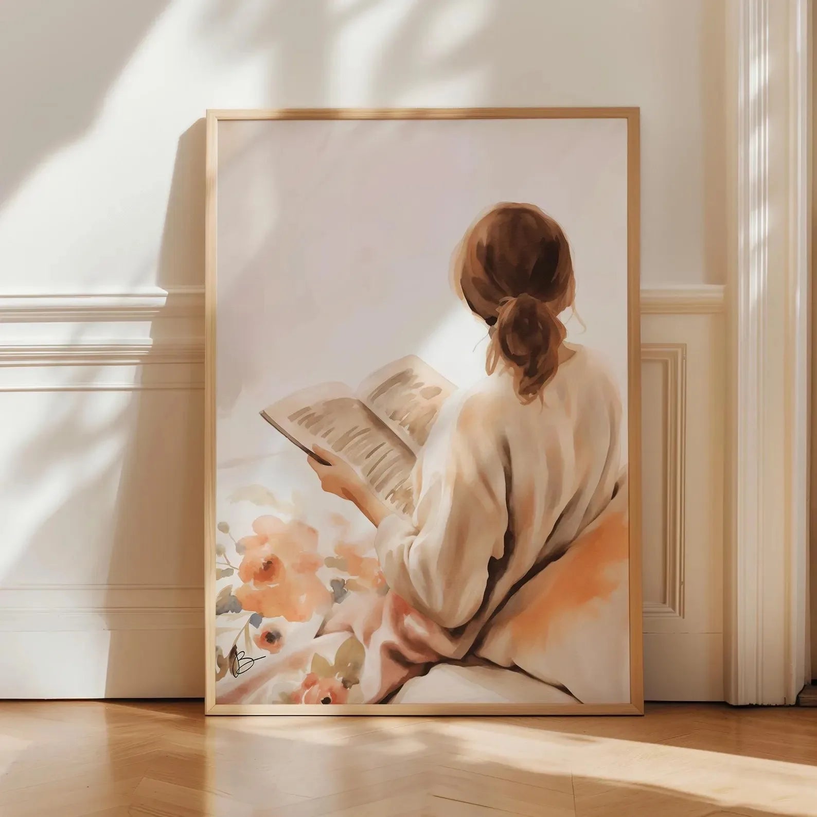 Framed artwork of a woman reading a book with flowers in a softly lit room.