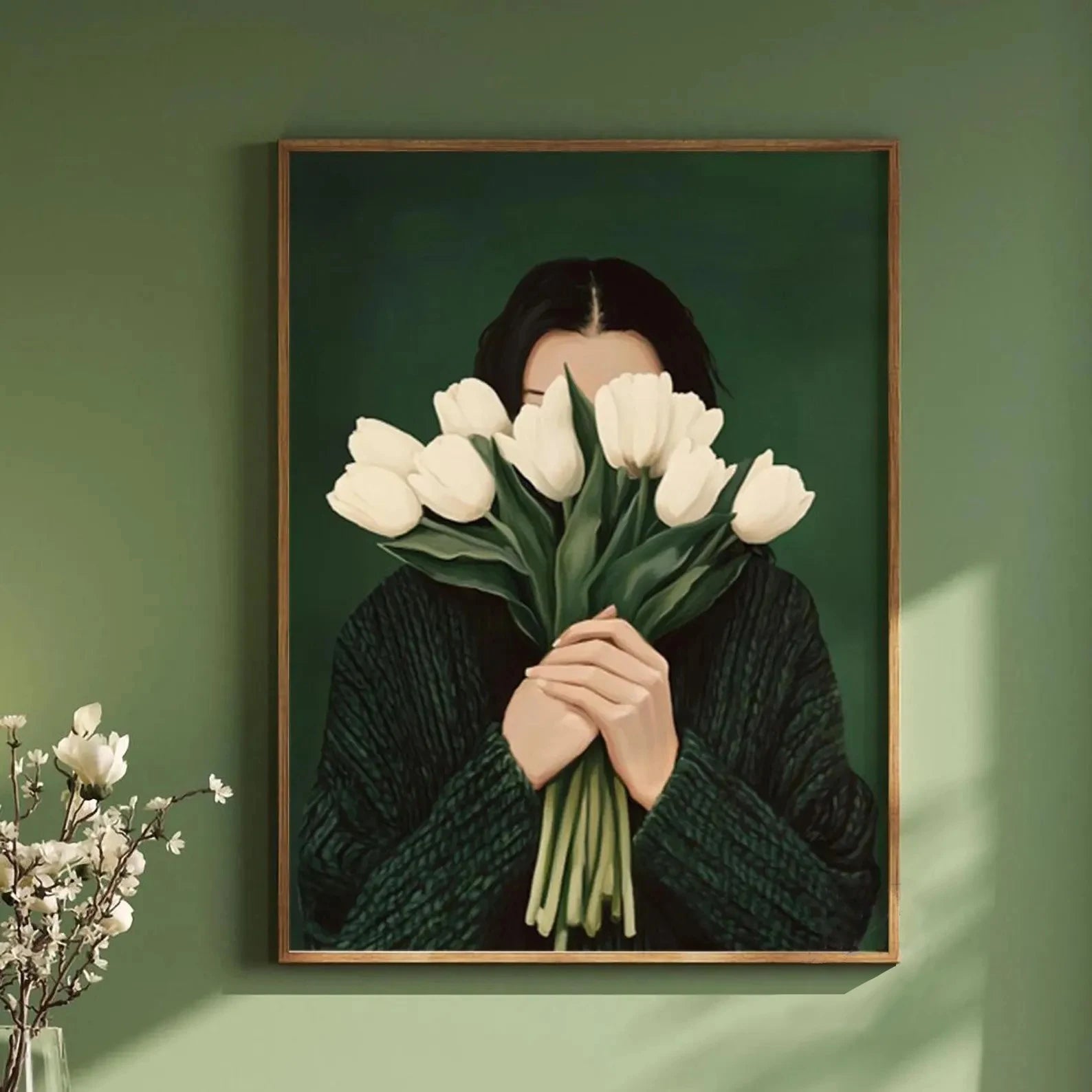 Framed artwork of a person holding white tulips against a green wall.