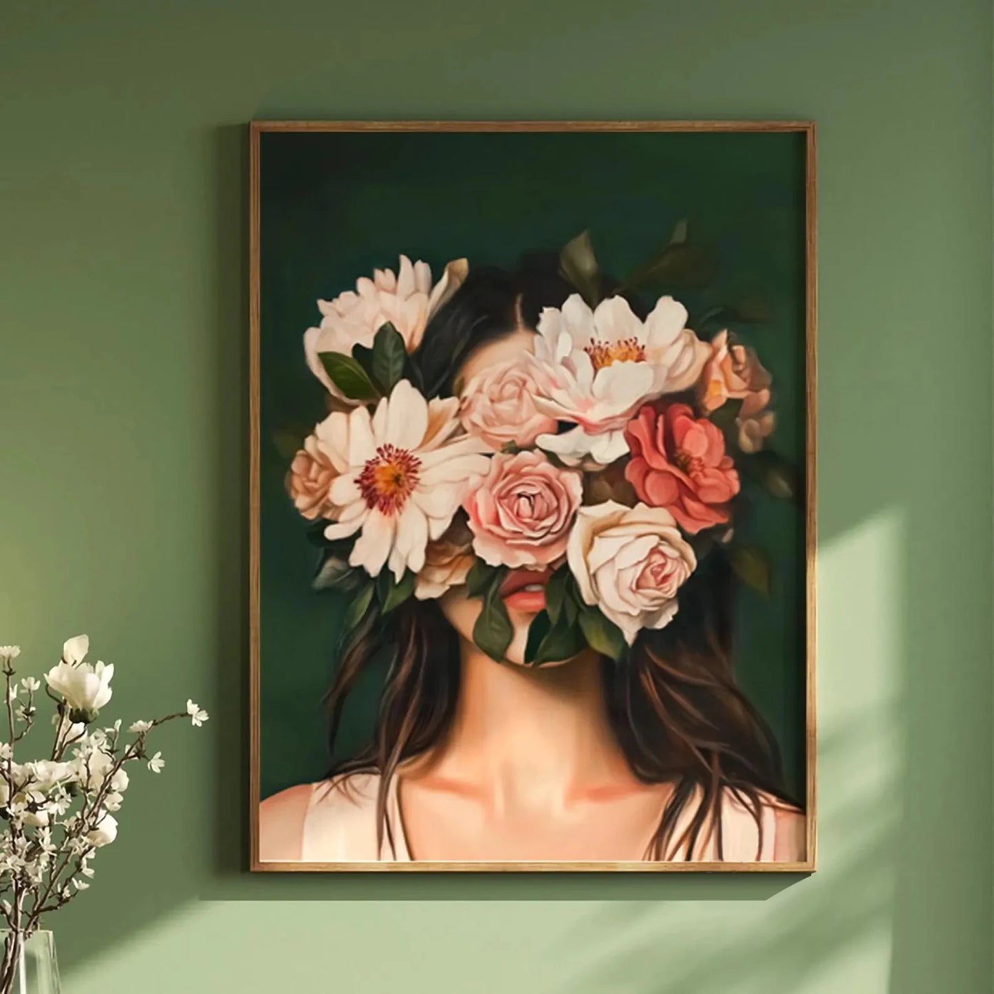 Framed artwork of a woman with flowers in her hair on a green wall.