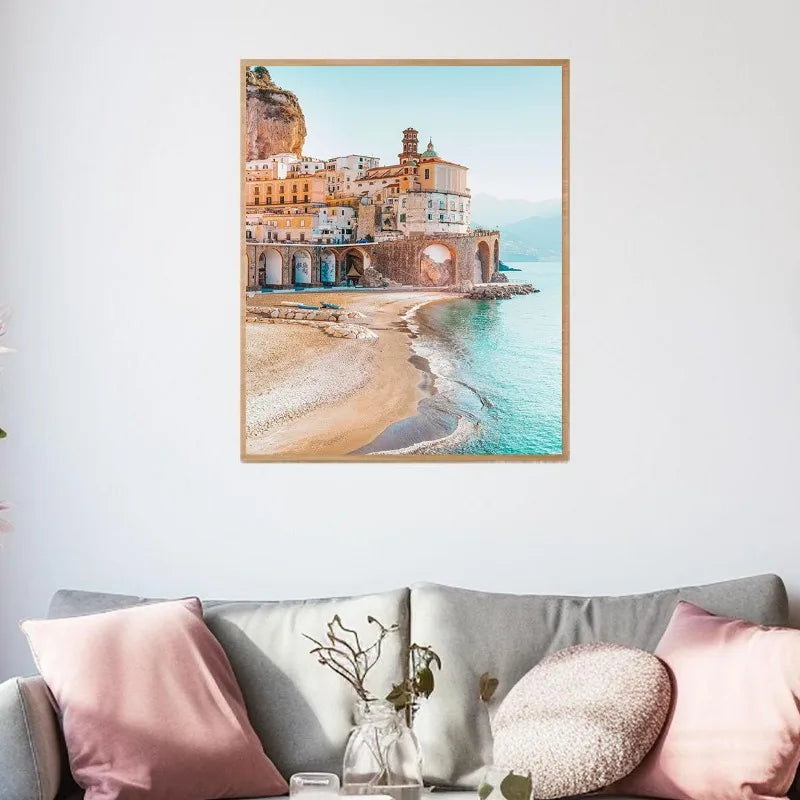 Framed artwork of a coastal scene above a sofa with decorative pillows.