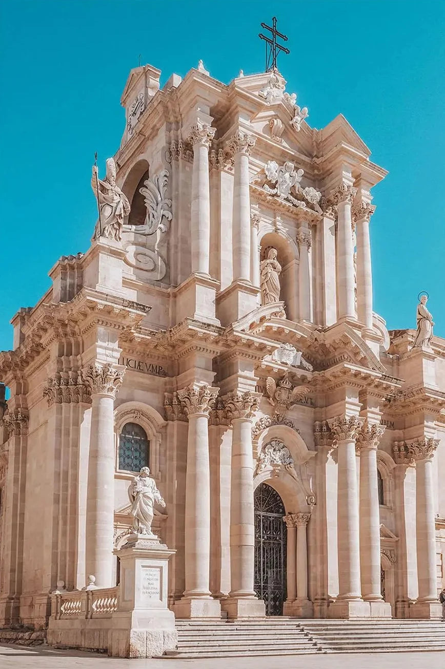 Baroque-style cathedral with intricate architecture against a clear blue sky