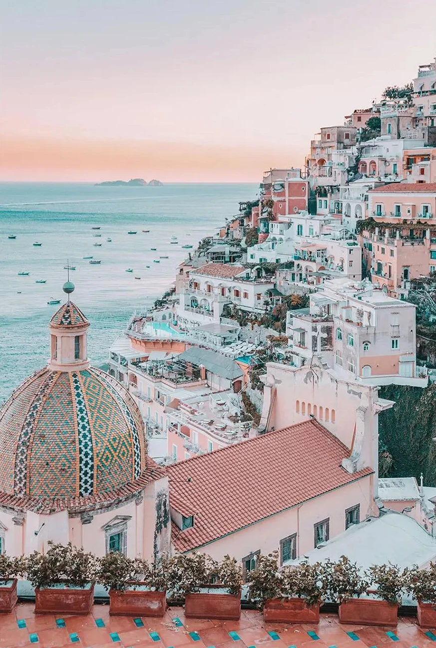 Vibrant coastal town with colorful buildings and a dome-shaped building, overlooking the sea.