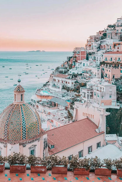 Vibrant coastal town with colorful buildings and a dome-shaped building, overlooking the sea.