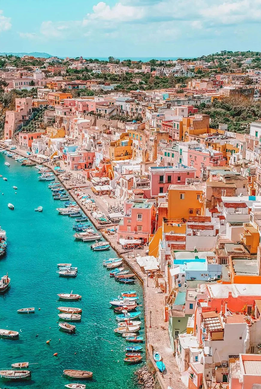 Colorful coastal town with buildings and boats near a turquoise sea