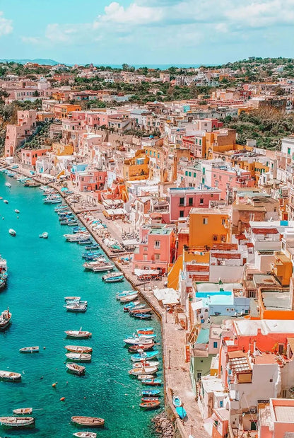Colorful coastal town with buildings and boats near a turquoise sea