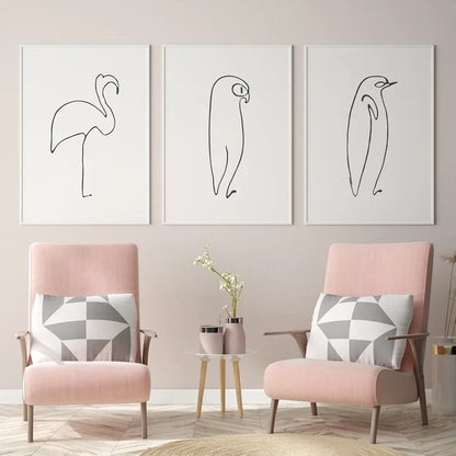 Two pink armchairs with geometric cushions in a room with wall art of line drawings.