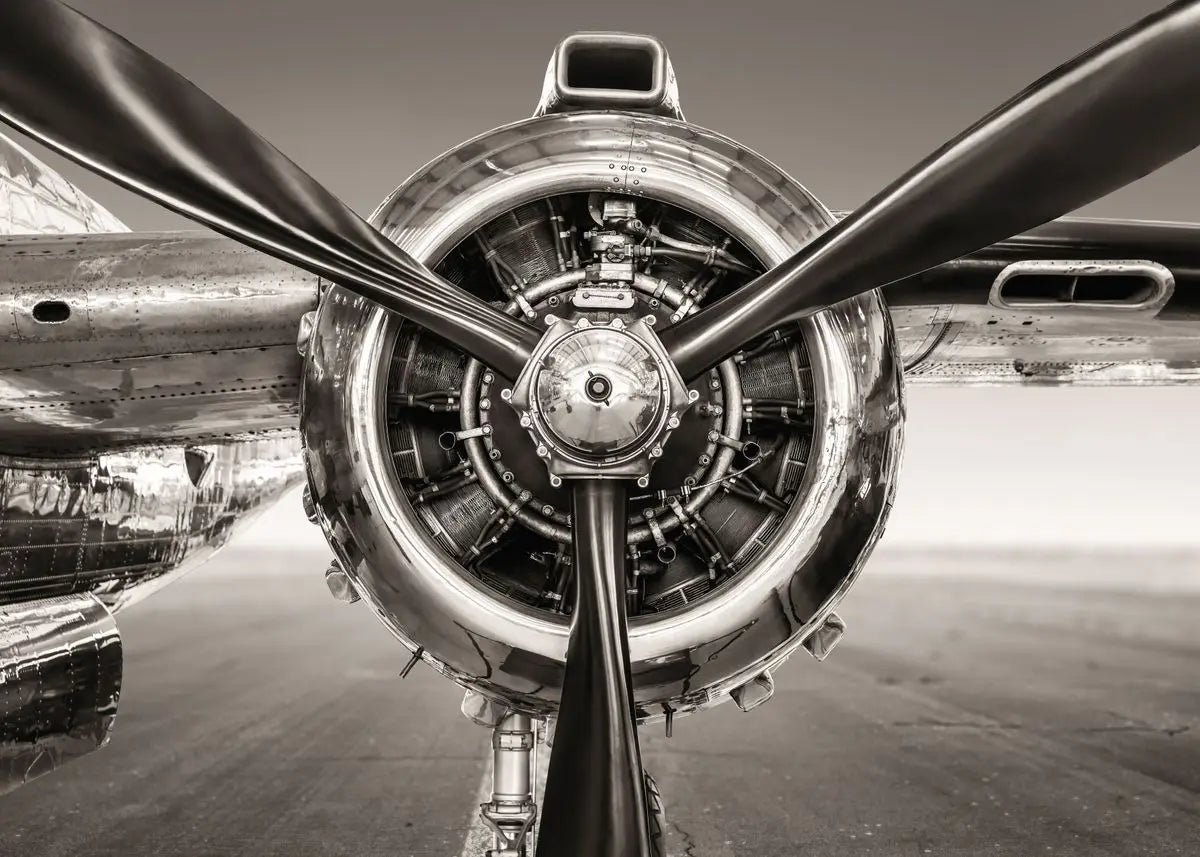 Close-up of a propeller and engine of an airplane in black and white.
