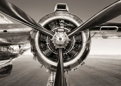 Close-up of a propeller and engine of an airplane in black and white.