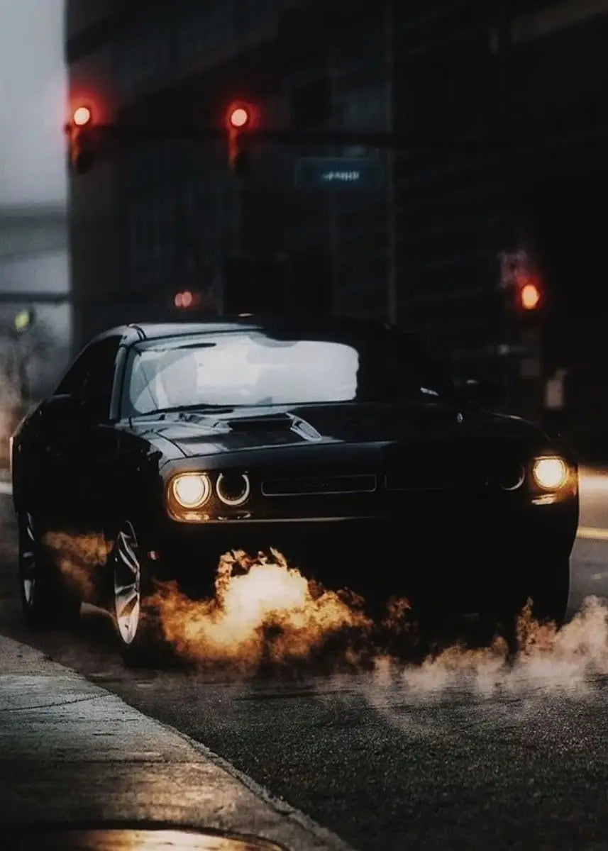 Black car with flames on a city street at night