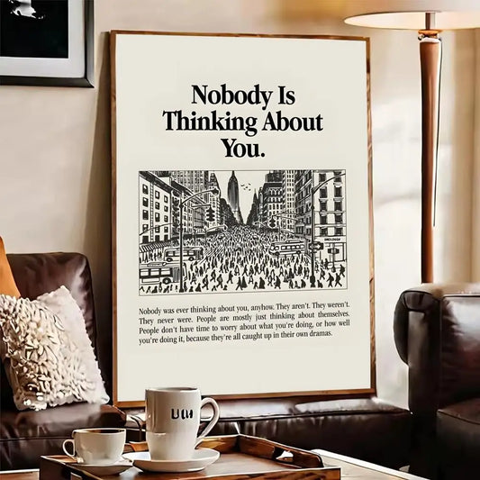 Framed poster with text 'Nobody Is Thinking About You' in a living room setting. Canvas & Curio