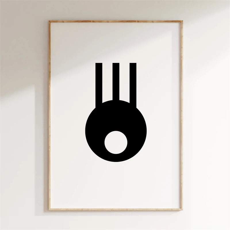 Framed abstract art print with a black symbol on a white wall
