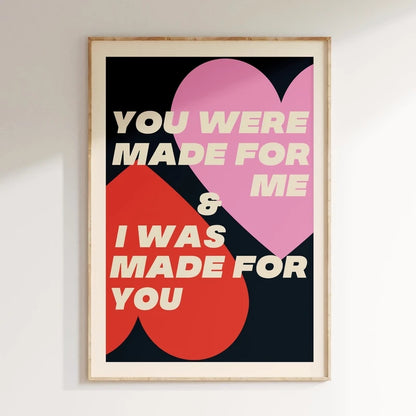 Framed poster with heart design and text on a white wall