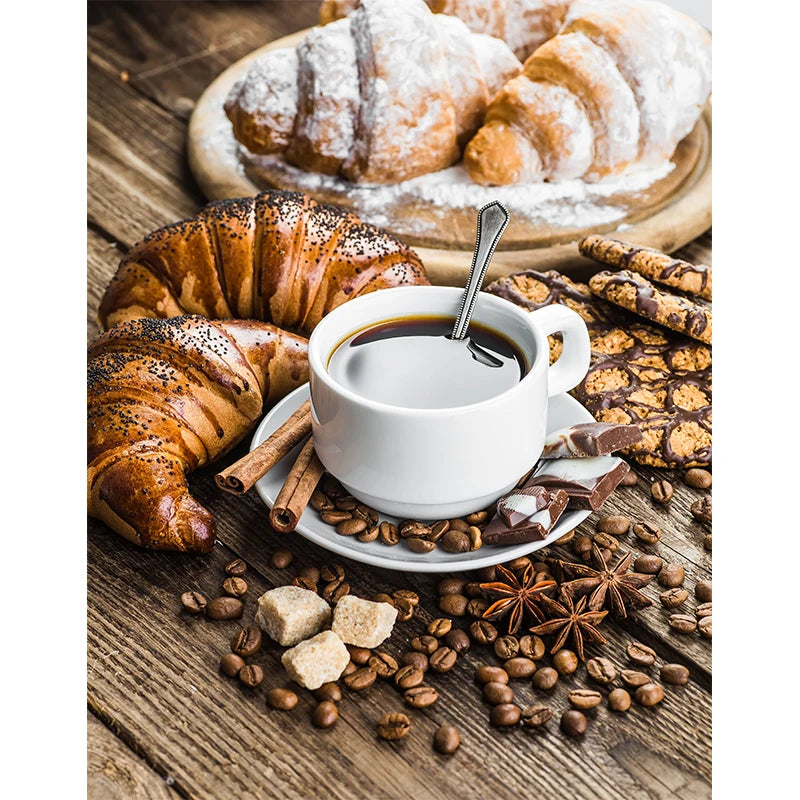 Cup of coffee with croissants and coffee beans on a wooden surface