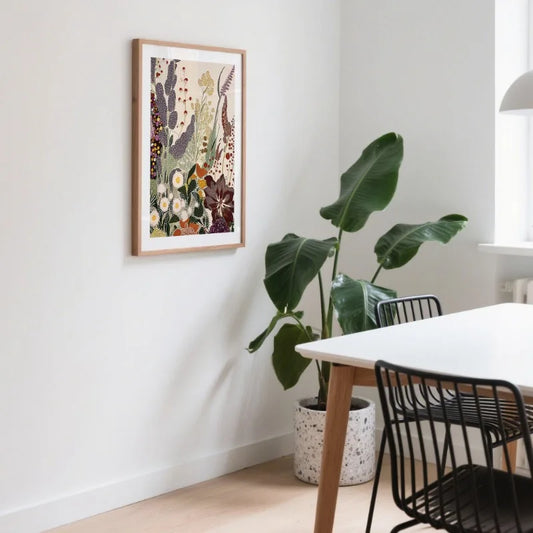 Modern interior with a framed floral print on the wall, a plant, and a dining table with chairs. Canvas & Curio