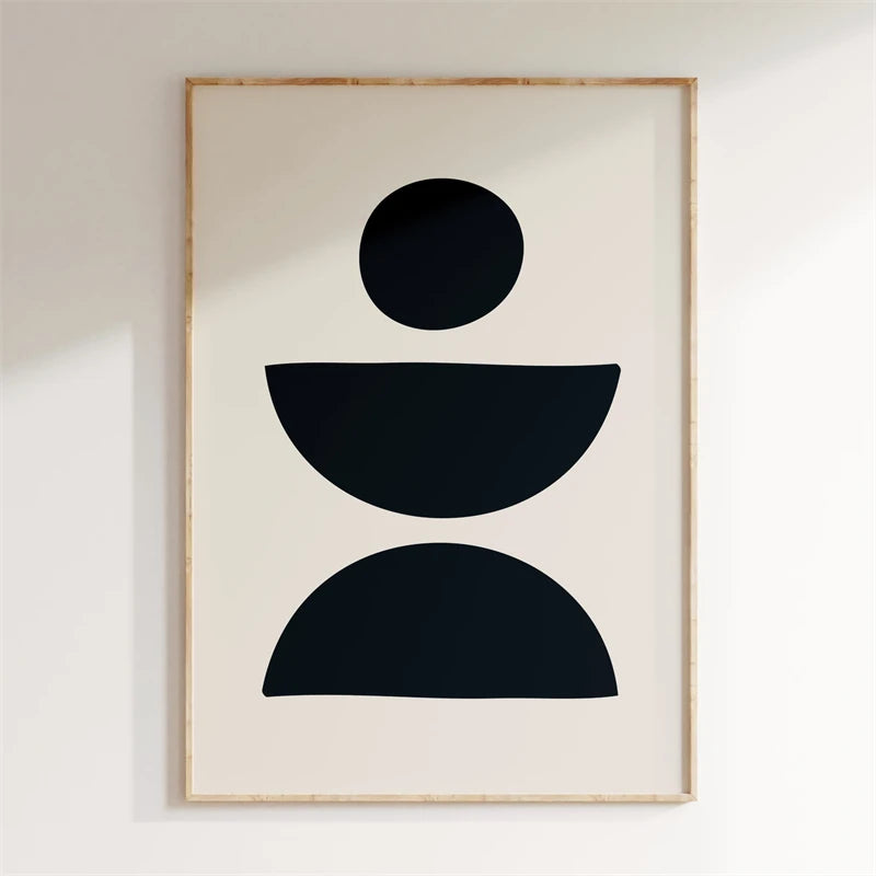 Framed abstract art with black shapes on a beige background