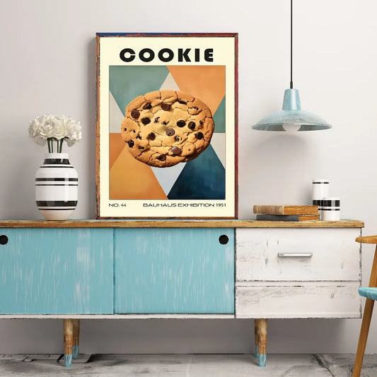 Framed poster of a cookie on a wall above a wooden cabinet. Canvas & Curio