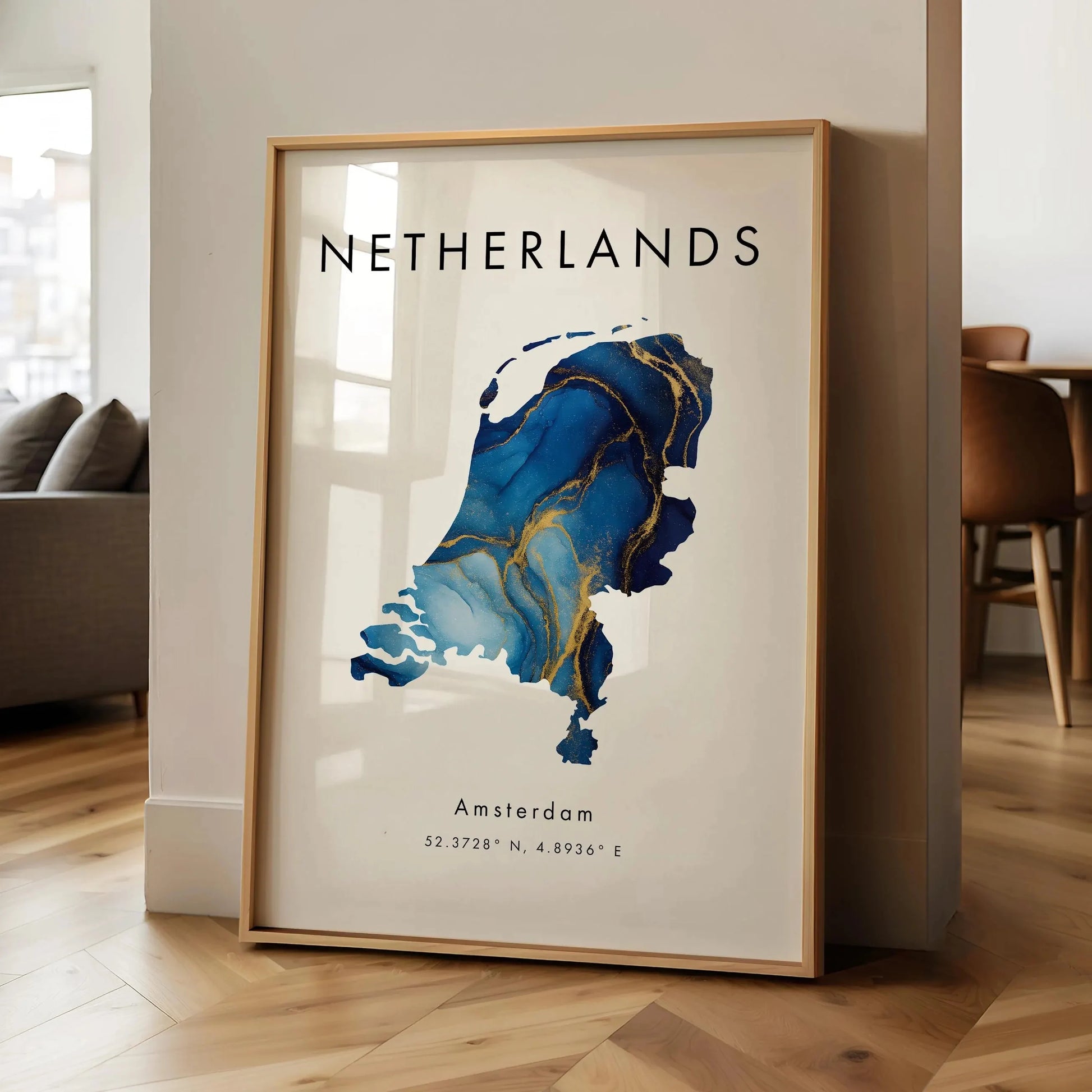 Framed map of the Netherlands with 'Netherlands' and 'Amsterdam' text in a room setting.