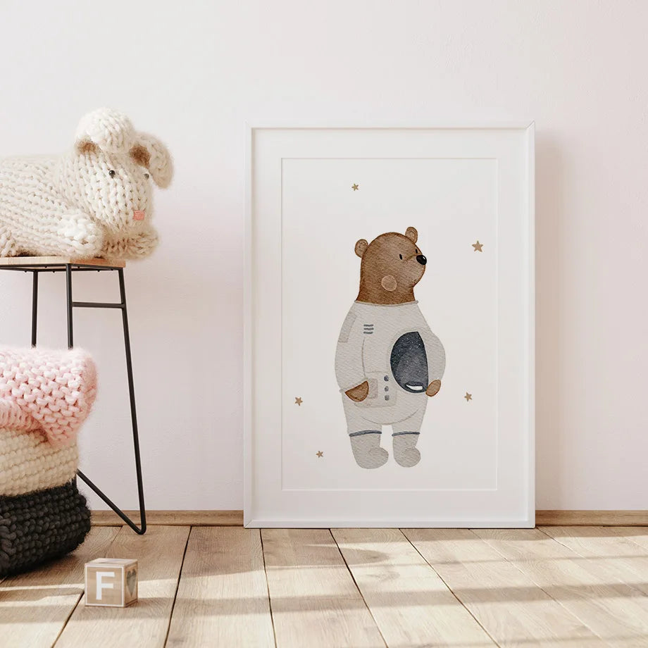 Framed artwork of a bear in an astronaut suit on a wall in a room with soft lighting.