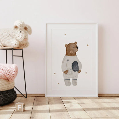 Framed artwork of a bear in an astronaut suit on a wall in a room with soft lighting.