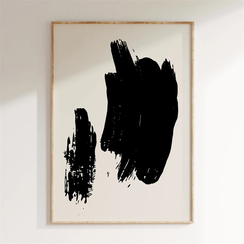 Framed abstract art with black brush strokes on a white wall