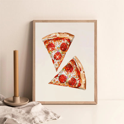 Framed artwork of two slices of pizza on a beige wall with a candle and fabric in the foreground.