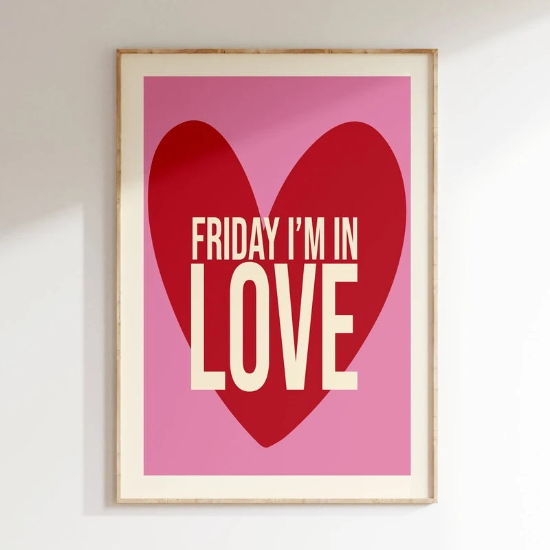 Framed poster with a red heart and 'Friday I'm in Love' text on a pink background