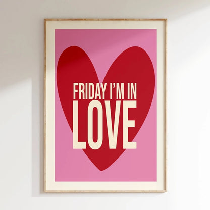 Framed poster with a red heart and 'Friday I'm in Love' text on a pink background