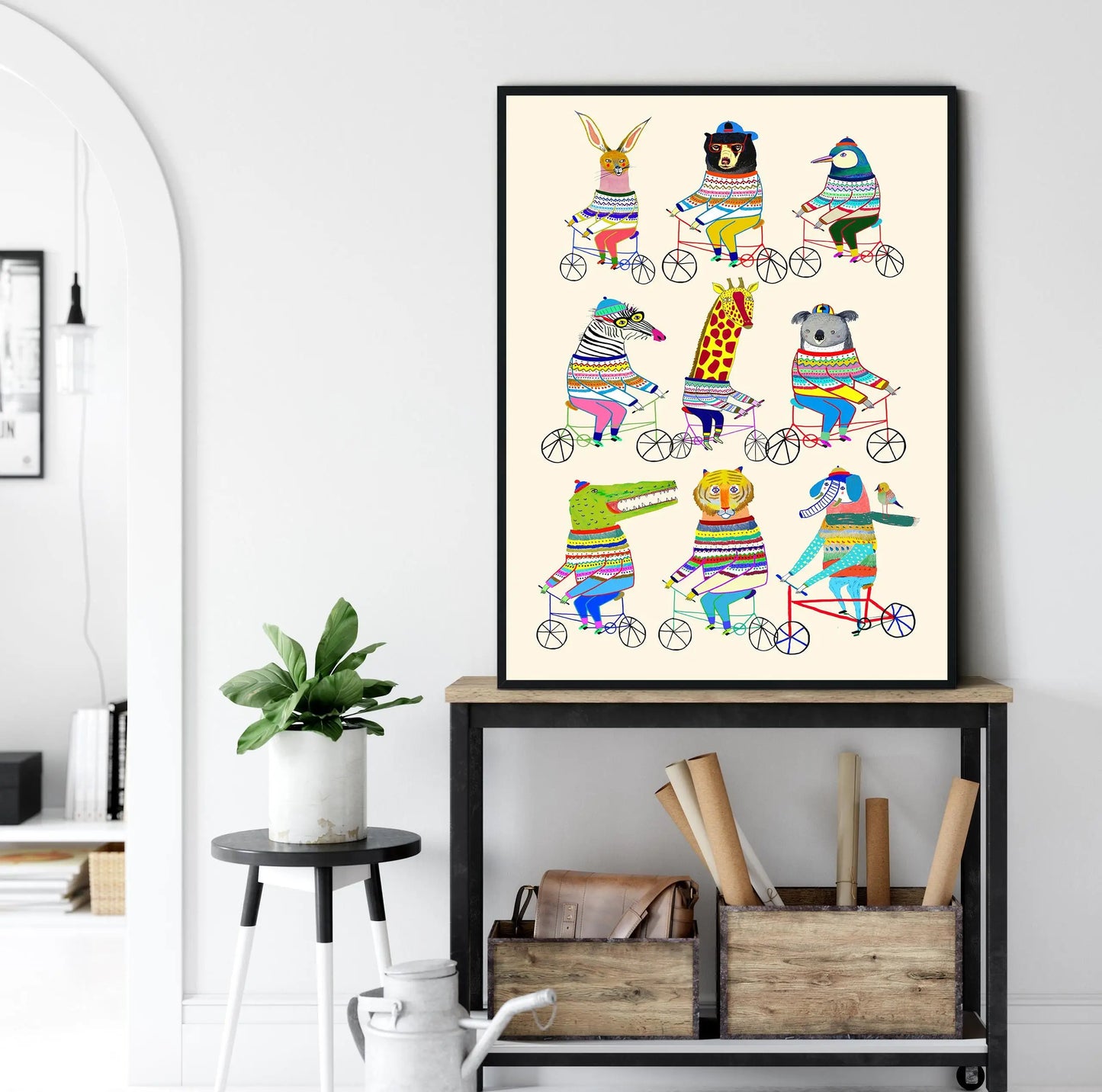 Framed colorful animal illustration on a wall above a shelf with books and plants.