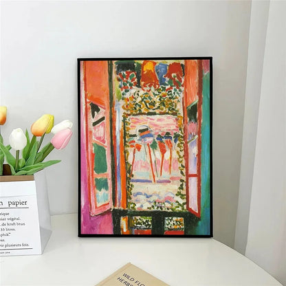 Framed colorful painting on a white surface with flowers and books in the background