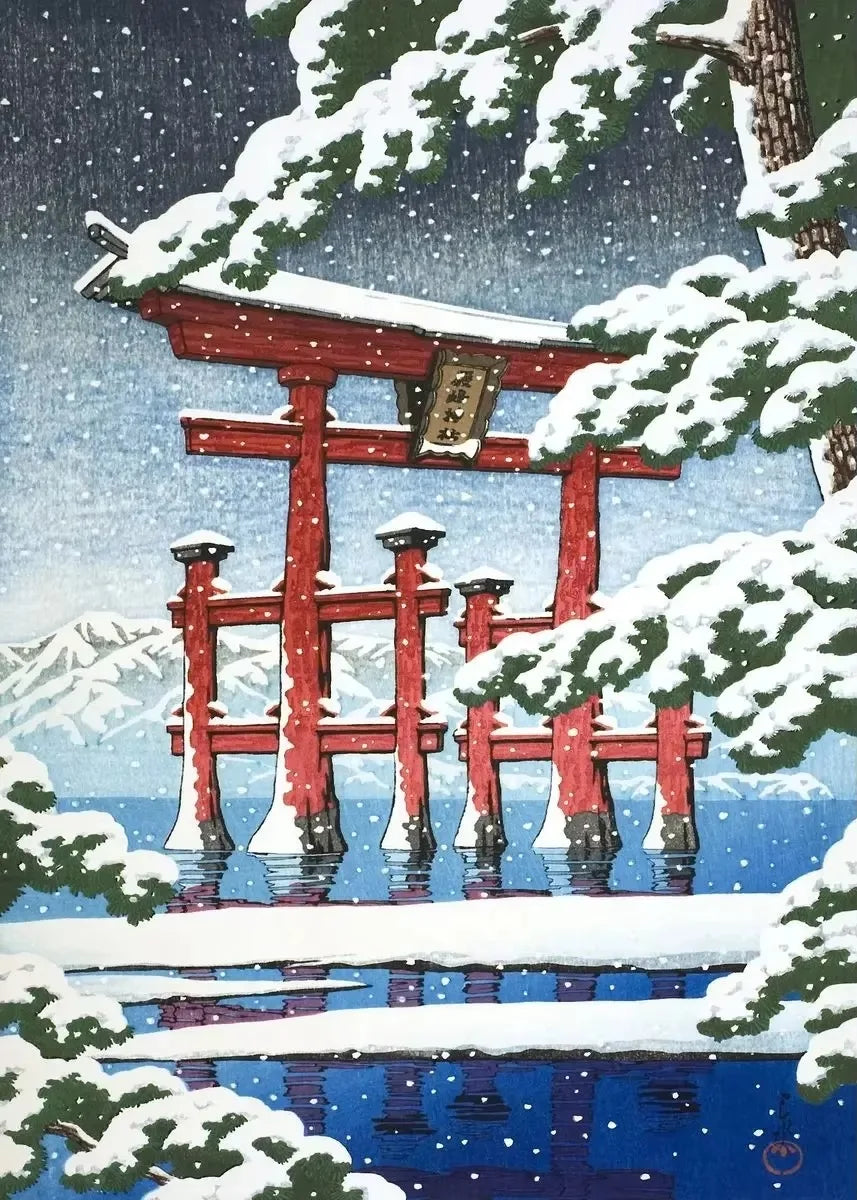 Red torii gate in a snowy landscape with mountains in the background