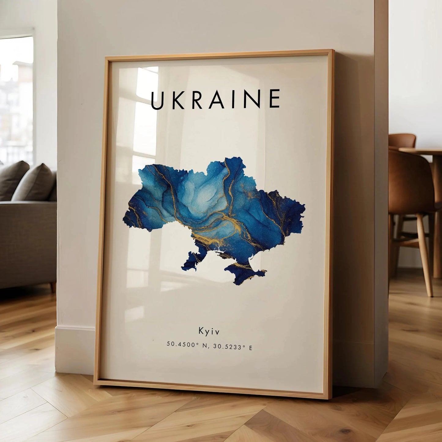 Framed map of Ukraine with 'Kyiv' coordinates on a wall in a room.