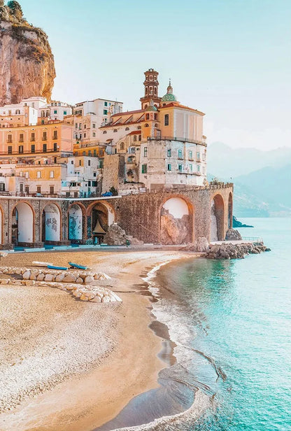 Coastal town with buildings built into a cliff overlooking turquoise water