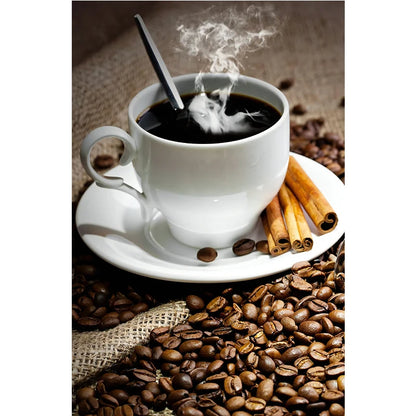 Steaming coffee cup with cinnamon sticks on a saucer surrounded by coffee beans.