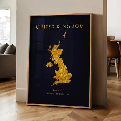 Framed artwork of a gold map of the United Kingdom on a dark background, displayed in a room with wooden flooring and furniture.