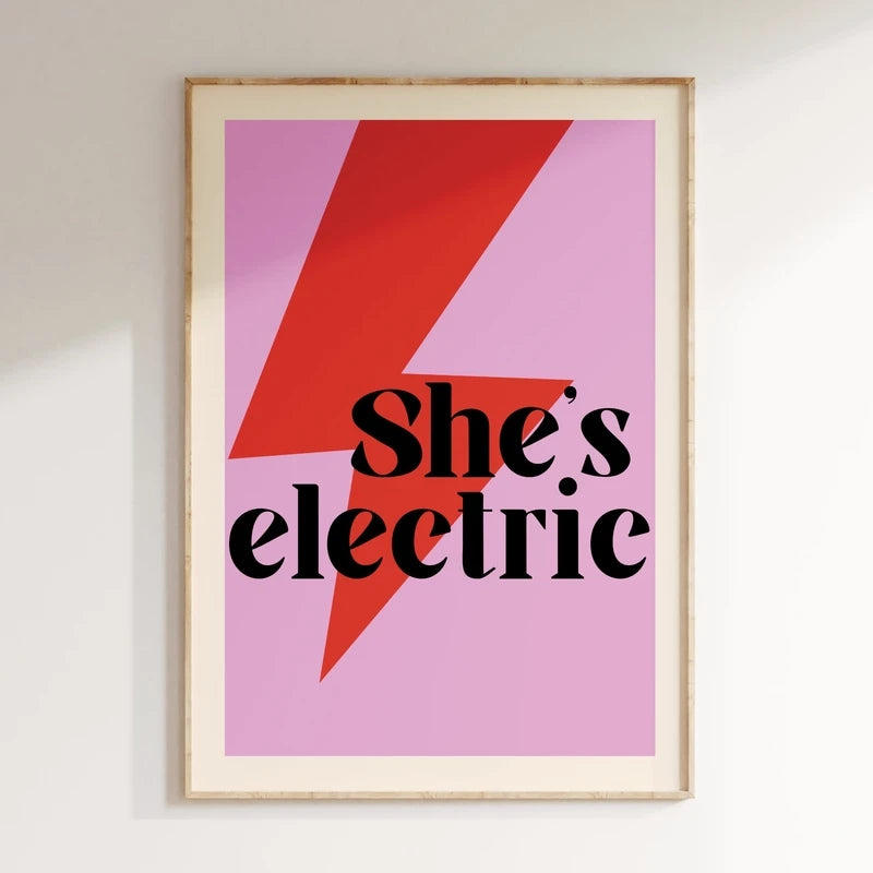 Framed poster with 'She's electric' text on a pink background