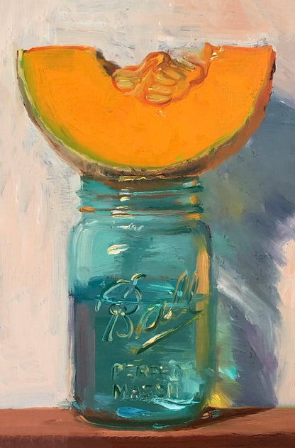 Sliced cantaloupe on a blue Ball jar against a textured background