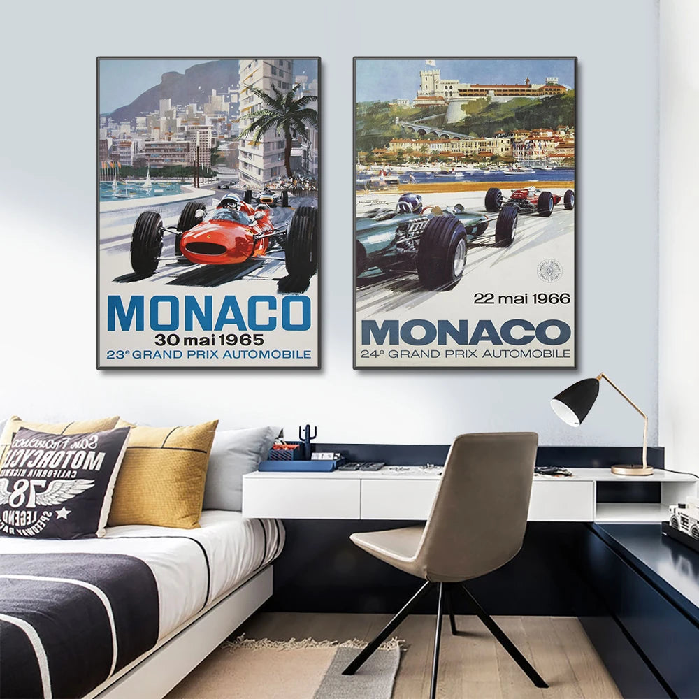 Two framed posters of Monaco Grand Prix on a wall above a modern office setup.