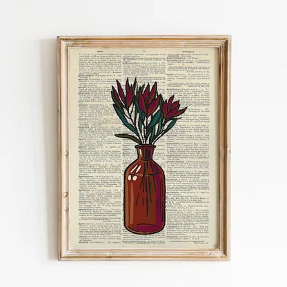Framed artwork of a vase with flowers on a printed page background