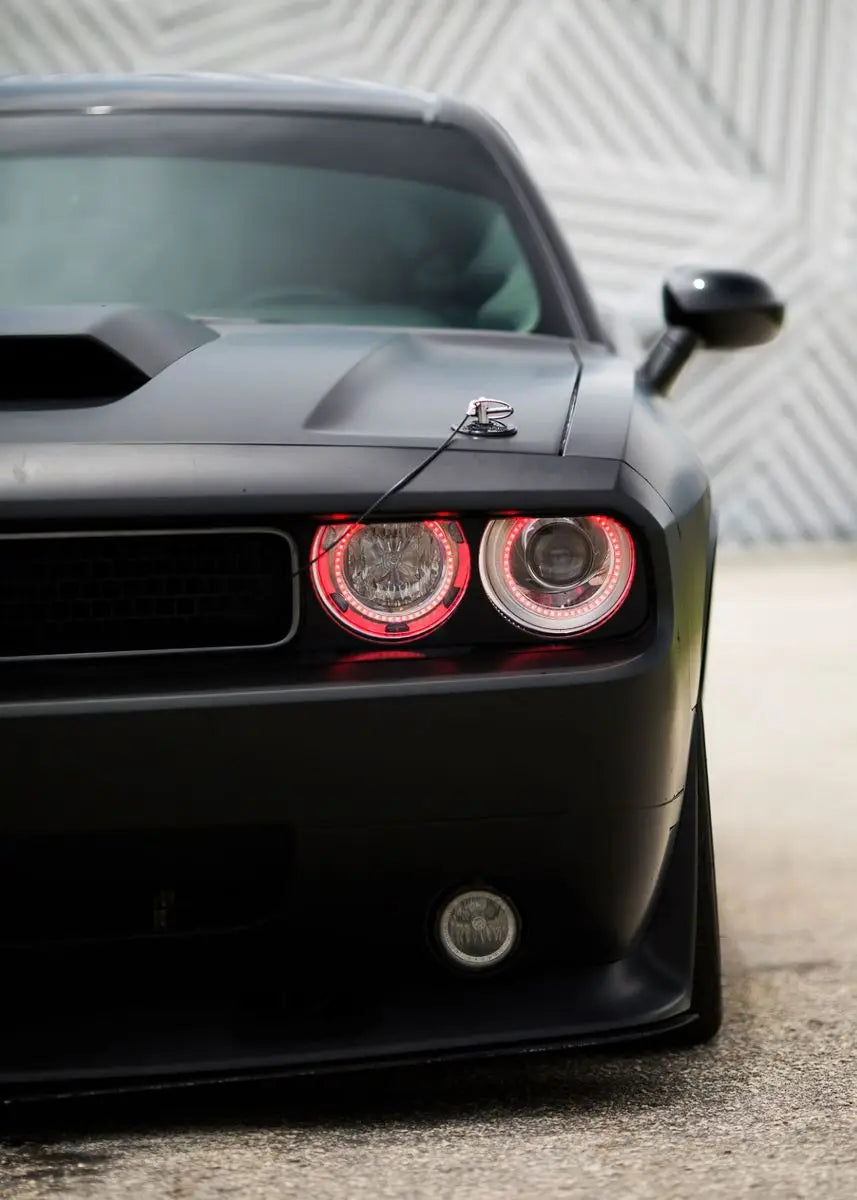 Black car with red and white headlights on a textured wall background