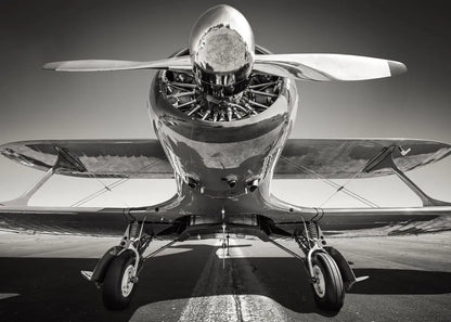 Black and white photo of a vintage airplane with a prominent propeller.